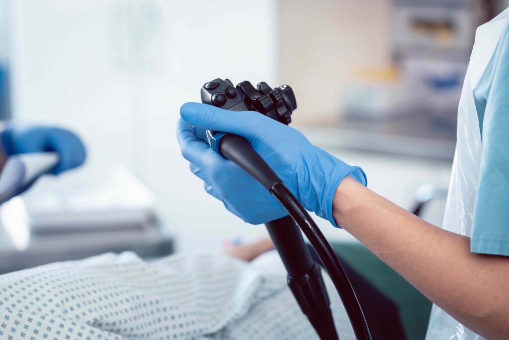 Close up of gloved hand holding a colonoscopy tool