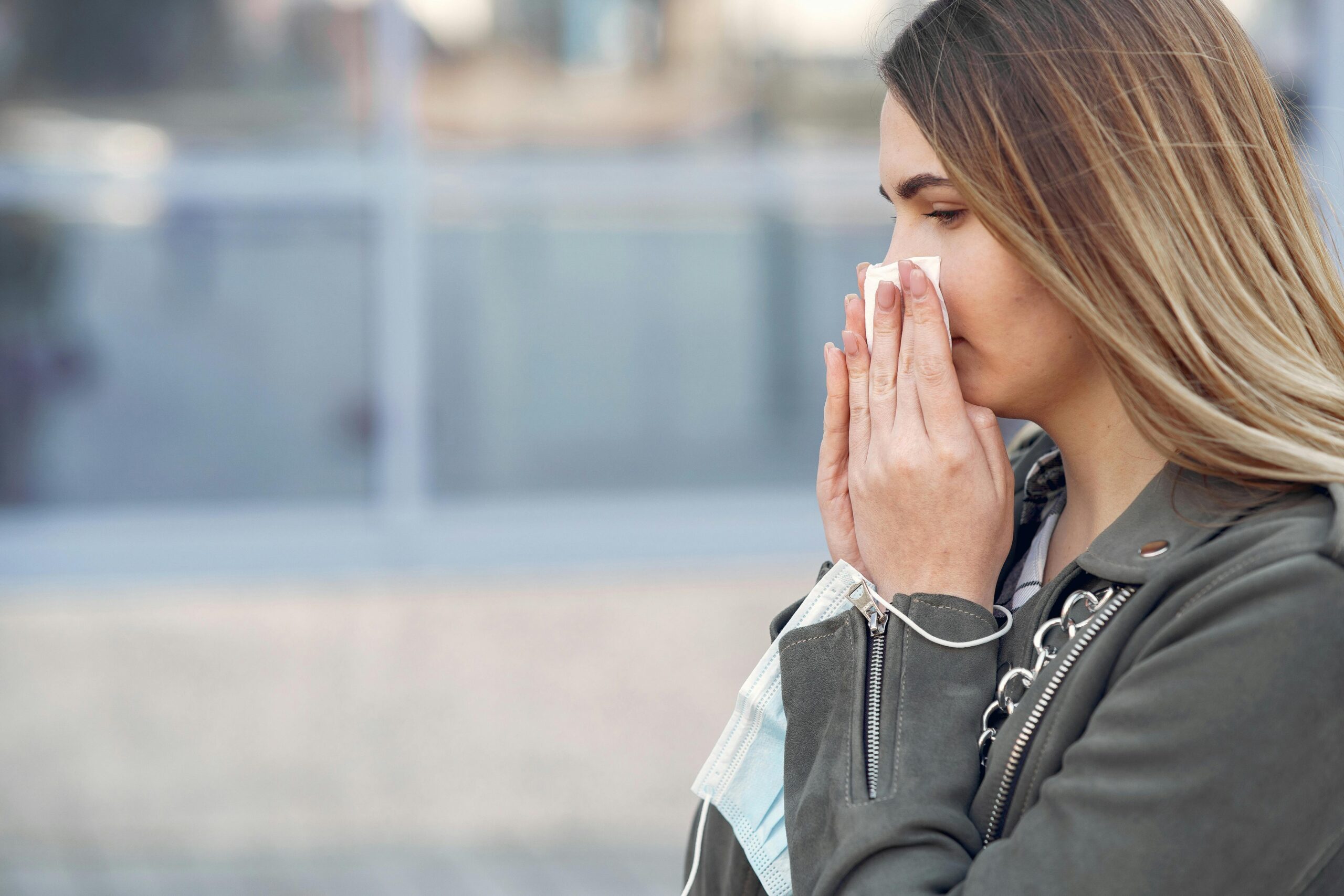 woman holding a tissue to her nose