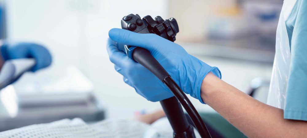 Close up of gloved hand holding a colonoscopy tool