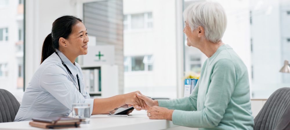 Doctor handshake, senior woman and healthcare with thank you in a hospital for medical care. Elderly consultation, smile and insurance conversation with women in a clinic office for retirement advice.