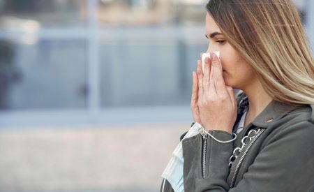 woman holding a tissue to her nose