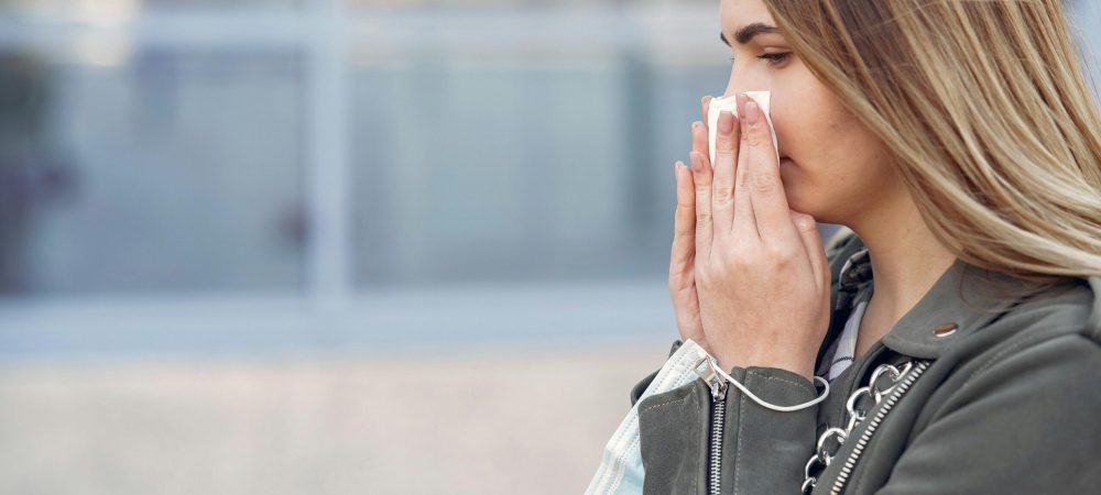 woman holding a tissue to her nose